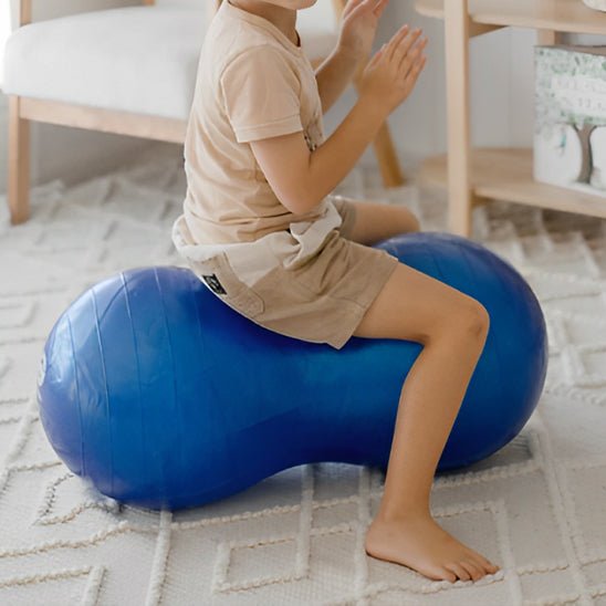 ballon de gym fillette assise sur ballon jambe par terre