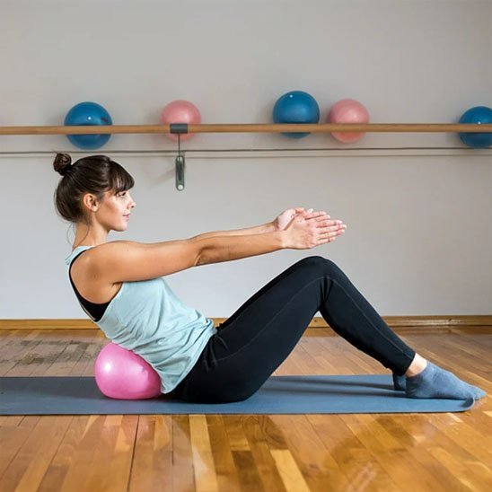 Ballon pilates femme pratique redressement assis avec ballon dans le dos